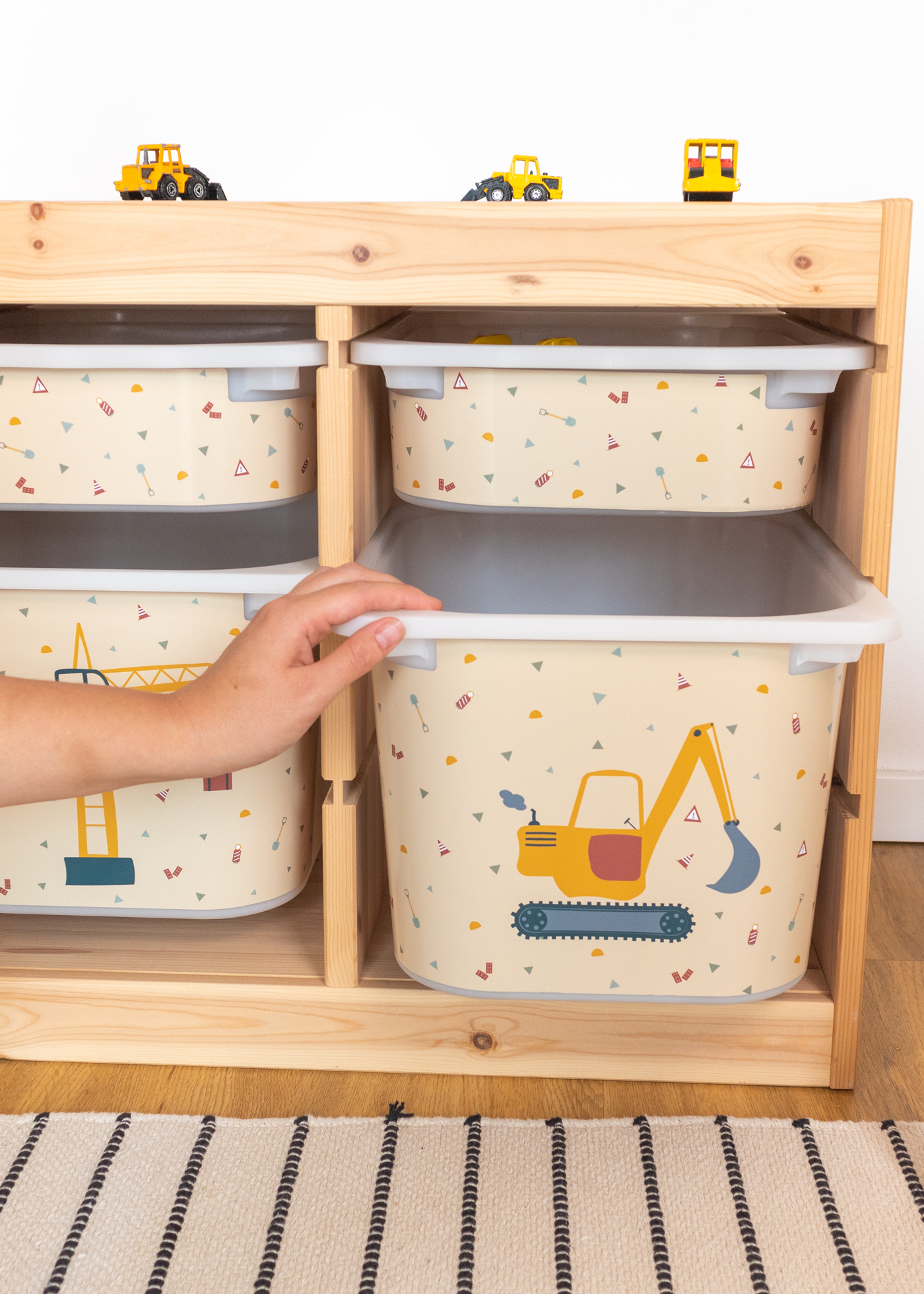 Aufbewahrungsbox im Regal mit Bagger-Motiv Aufbewahrungsbox im IKEA TROFAST Regal mit gelbem Bagger-Motiv.