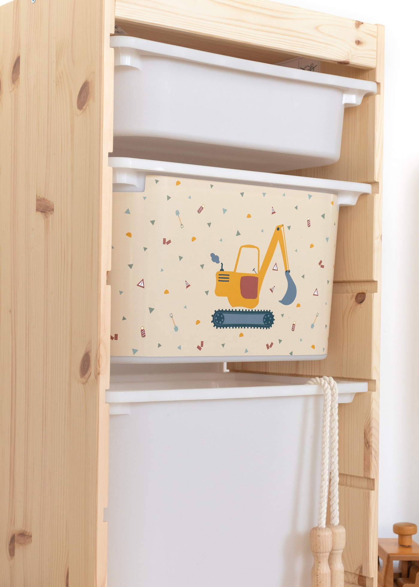 IKEA TROFAST Regal mit Bagger-Themenbox Praktische beige Box im TROFAST Regal, dekoriert mit Bagger-Motiv.