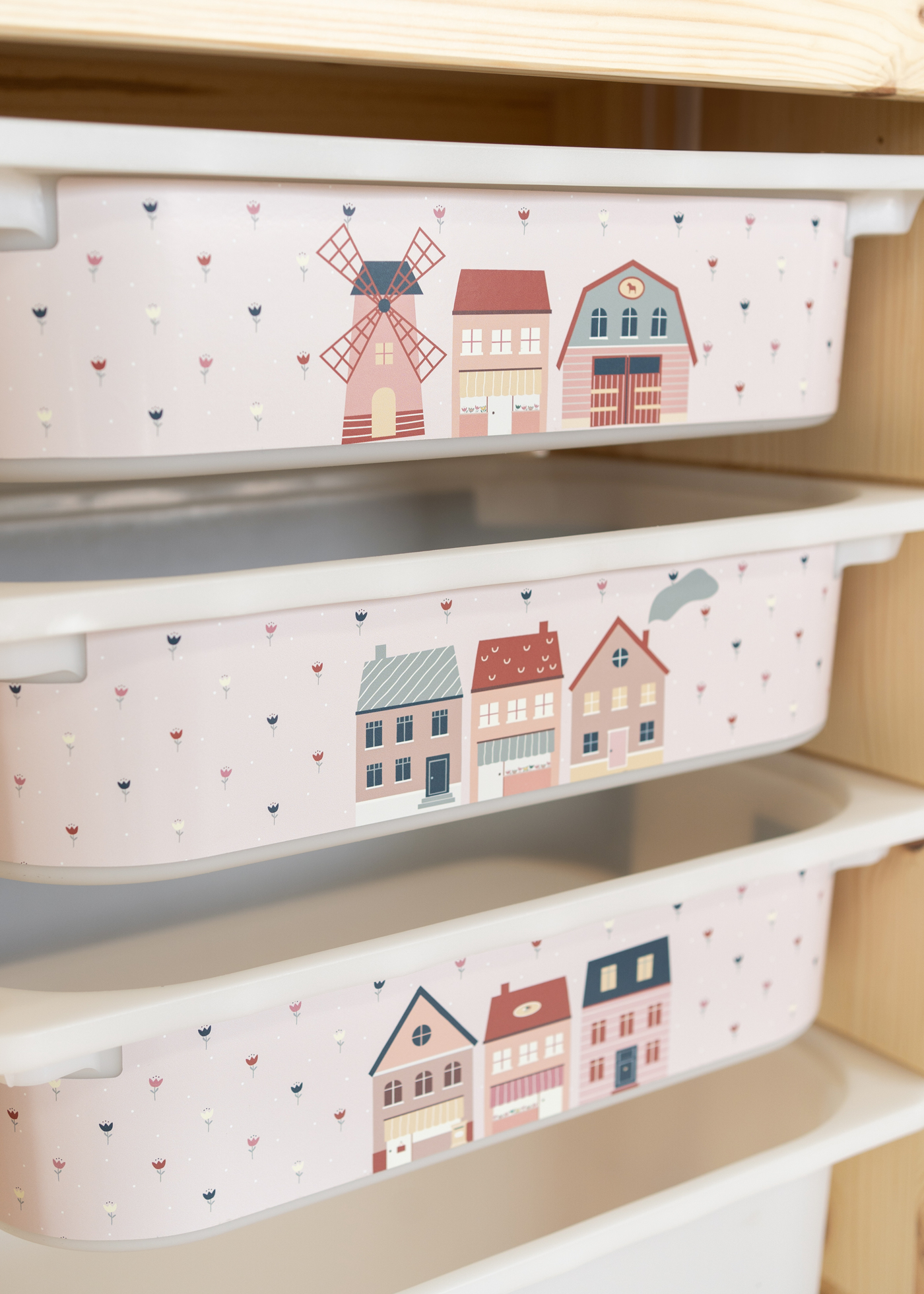 Rosa Aufbewahrungsbox im IKEA TROFAST Regal mit einer bunten Dorf-Szene. Rosa Aufbewahrungsbox im IKEA TROFAST Regal mit einer bunten Dorf-Szene.