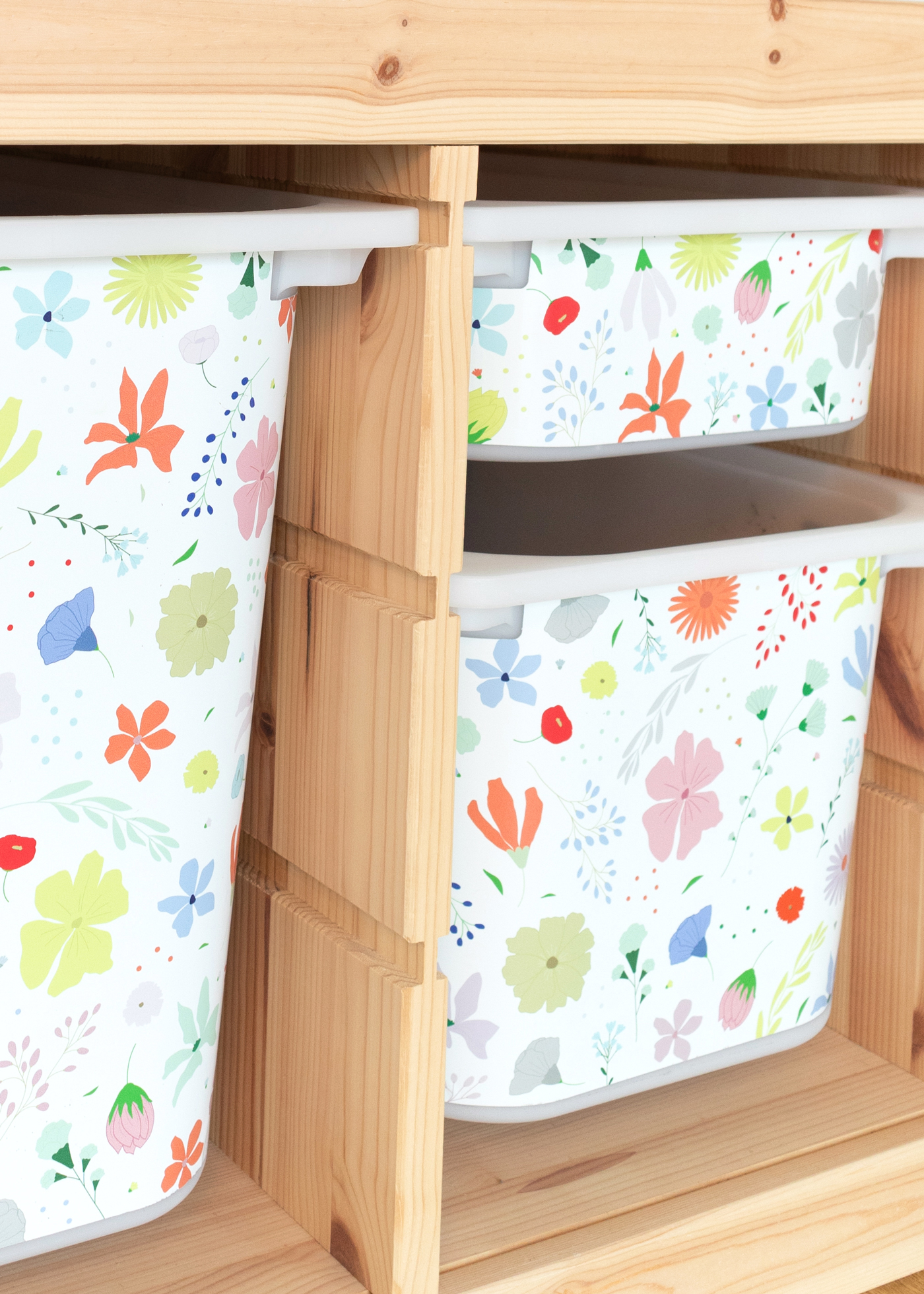 IKEA TROFAST mit bunten Blumen Ein IKEA TROFAST Regal im Zimmer, geschmückt mit einer floralen Klebefolie