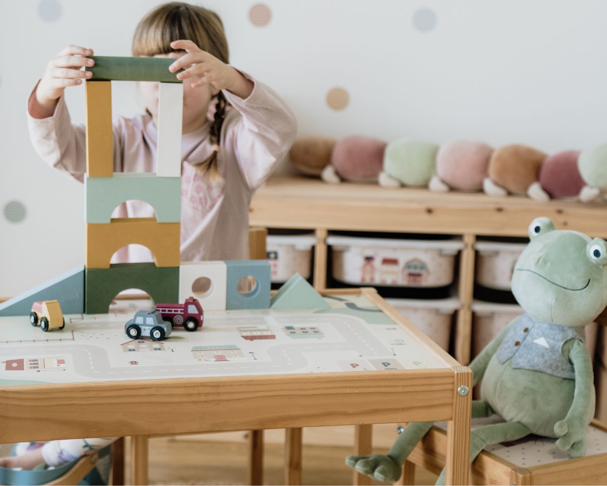 Maedchen spielt mit Bauklötzen am Spieltisch Maedchen spielt mit Bauklötzen am Spieltisch