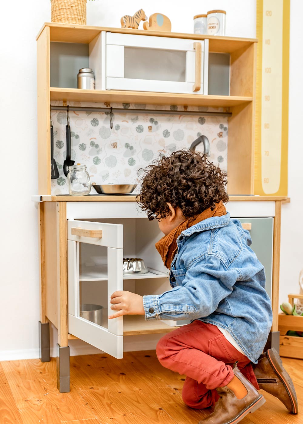 Holzgriffe für Kinderküche Ein Junge sitzt vor einer Kinderküche