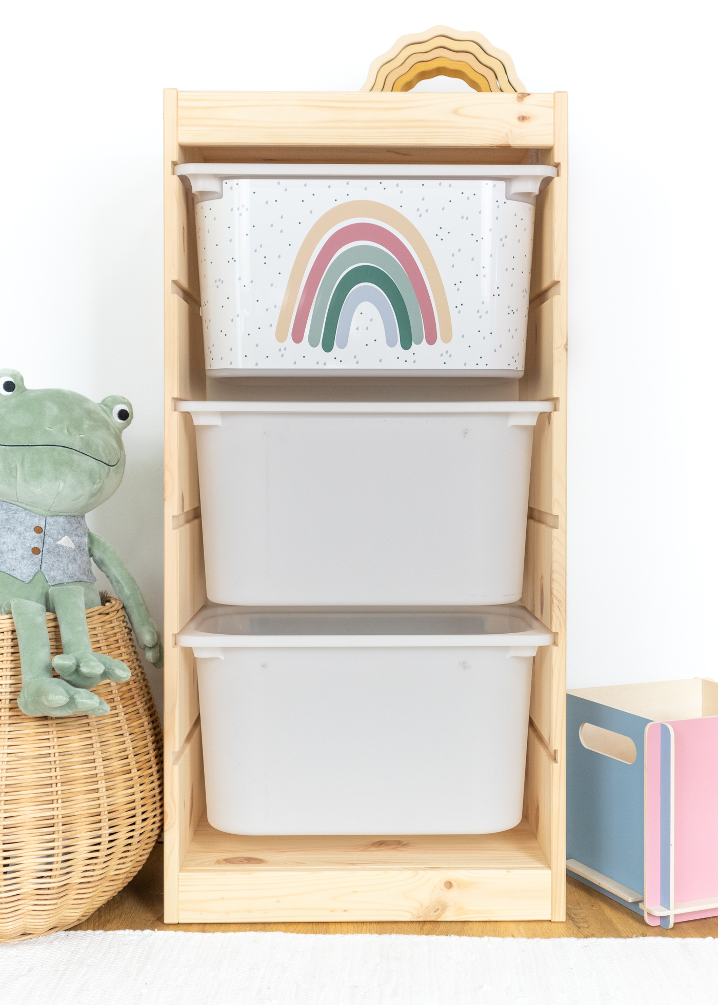 Beige Box mit Regenbogen im IKEA TROFAST Regal Kindgerechte beige Box im TROFAST Regal, bedruckt mit einem farbenfrohen Regenbogen.