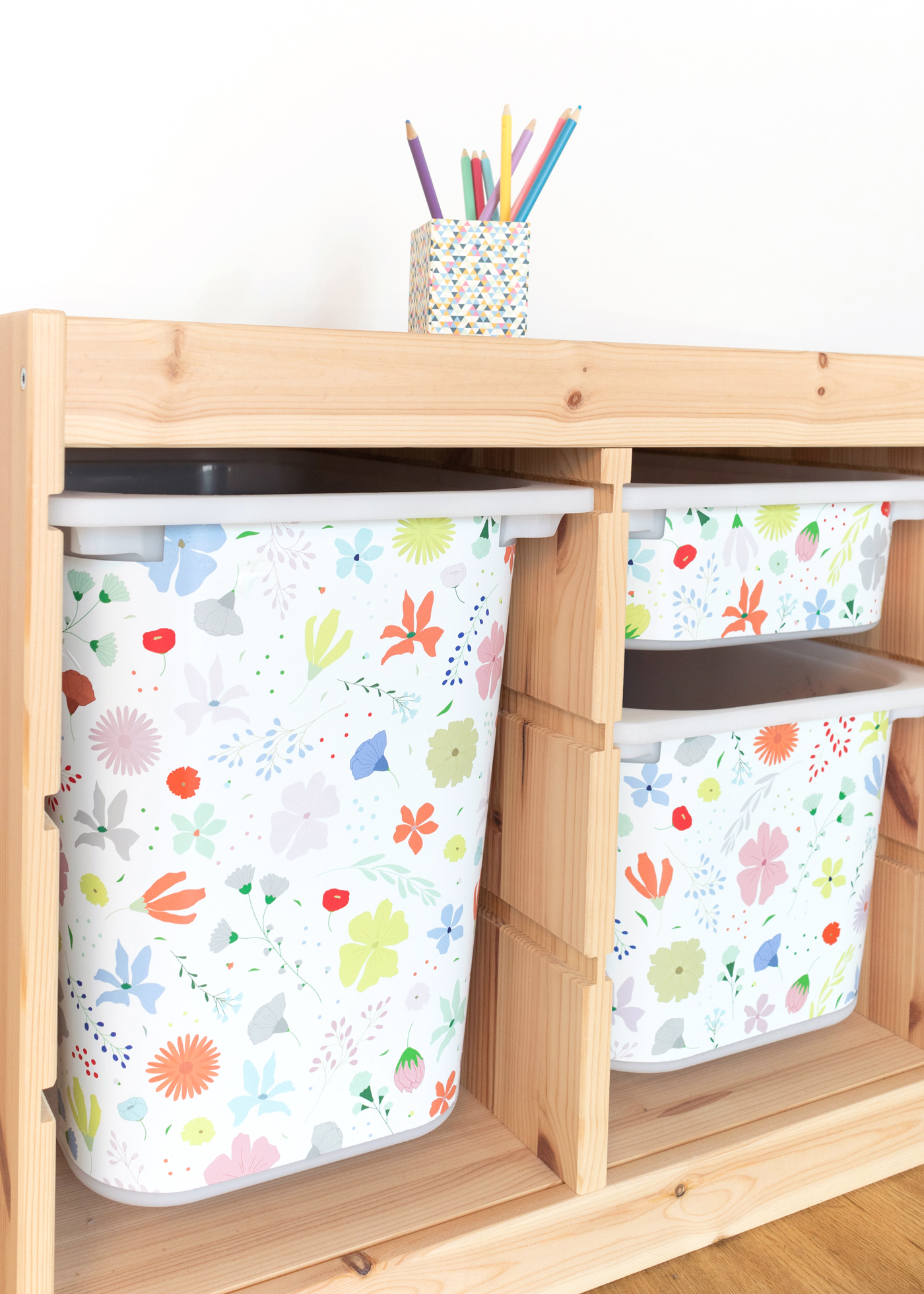 Ein IKEA TROFAST Regal mit bunter Möbelfolie mit Blumenmuster Ein IKEA TROFAST Regal mit bunter Möbelfolie mit Blumenmuster
