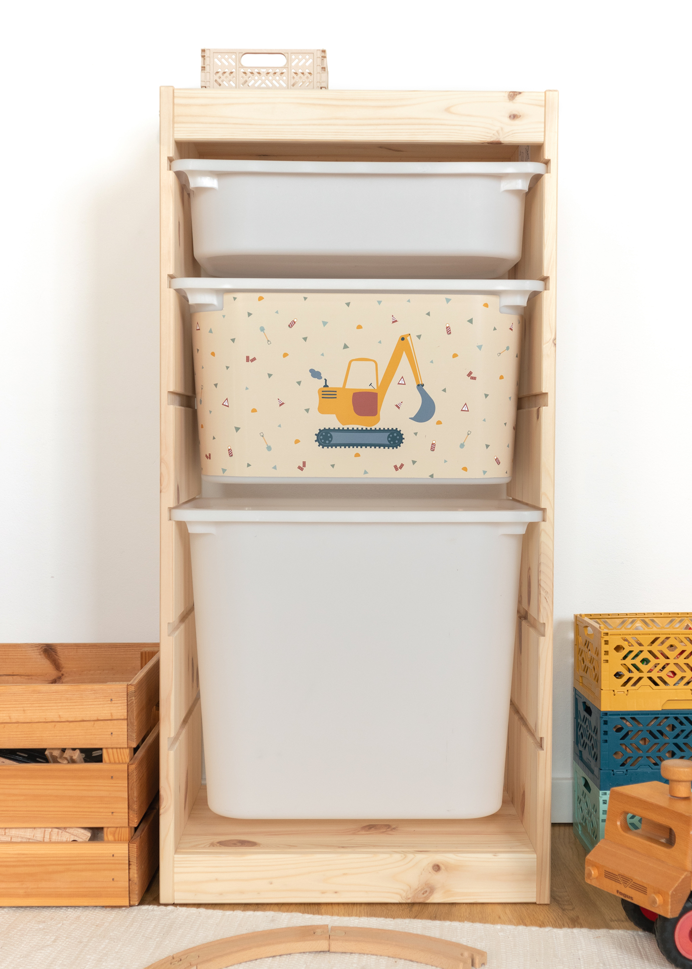 Bagger-Motiv auf beige Box im IKEA TROFAST Regal, ideal für Kinderzimmer.