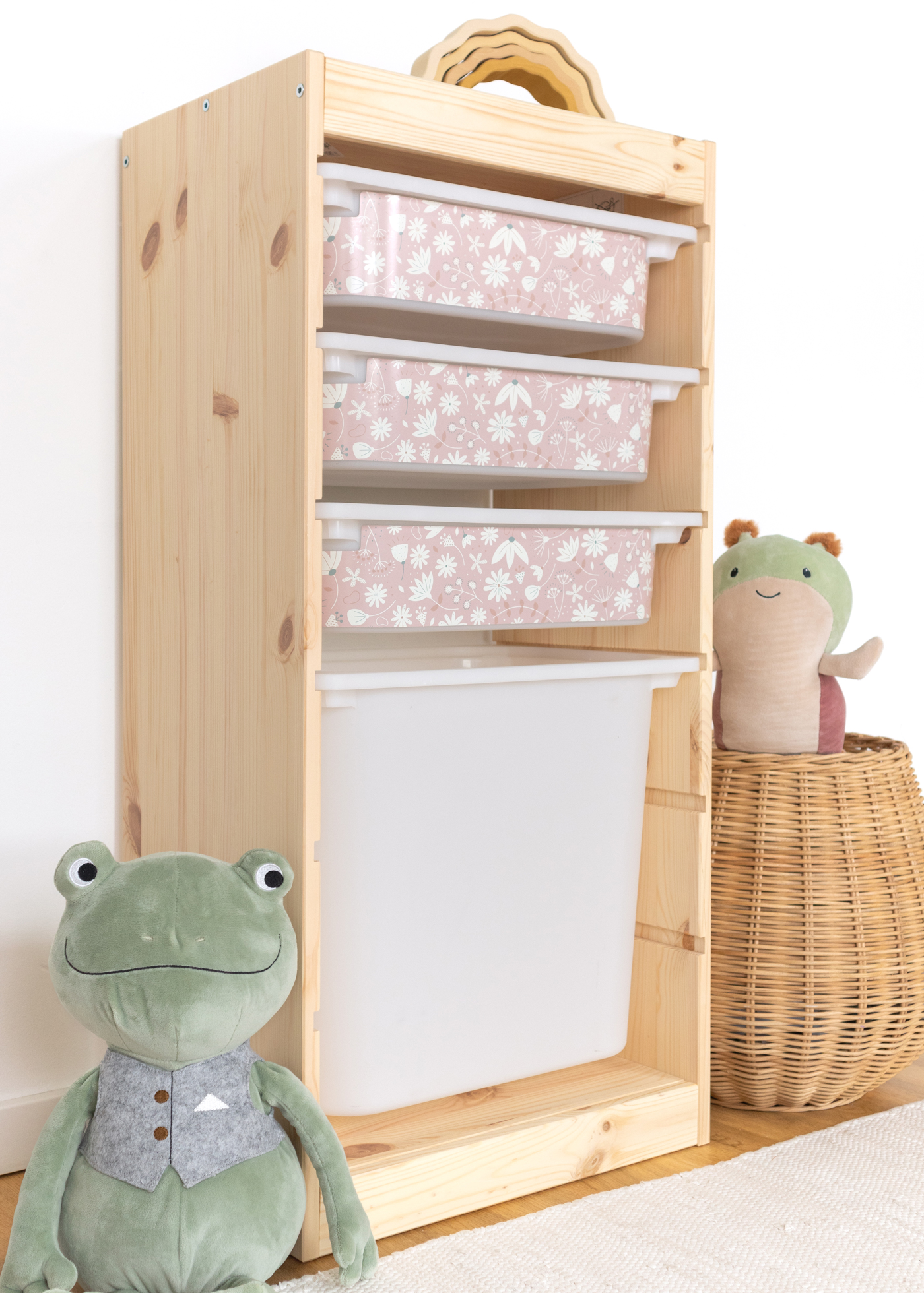 Kinder-Aufbewahrungsbox im TROFAST Regal mit rosa Blumenmuster Aufbewahrungsbox im IKEA TROFAST Regal, dekoriert mit einem blumigen rosa Muster.