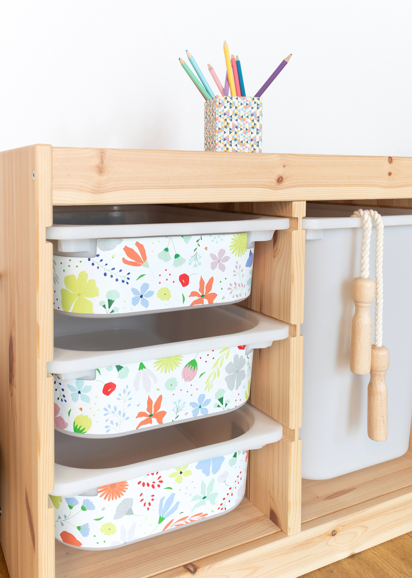 IKEA TROFAST Box mit Blumen Ein IKEA TROFAST Regal verziert mit farbenfroher Klebefolie mit Blumenmotiven