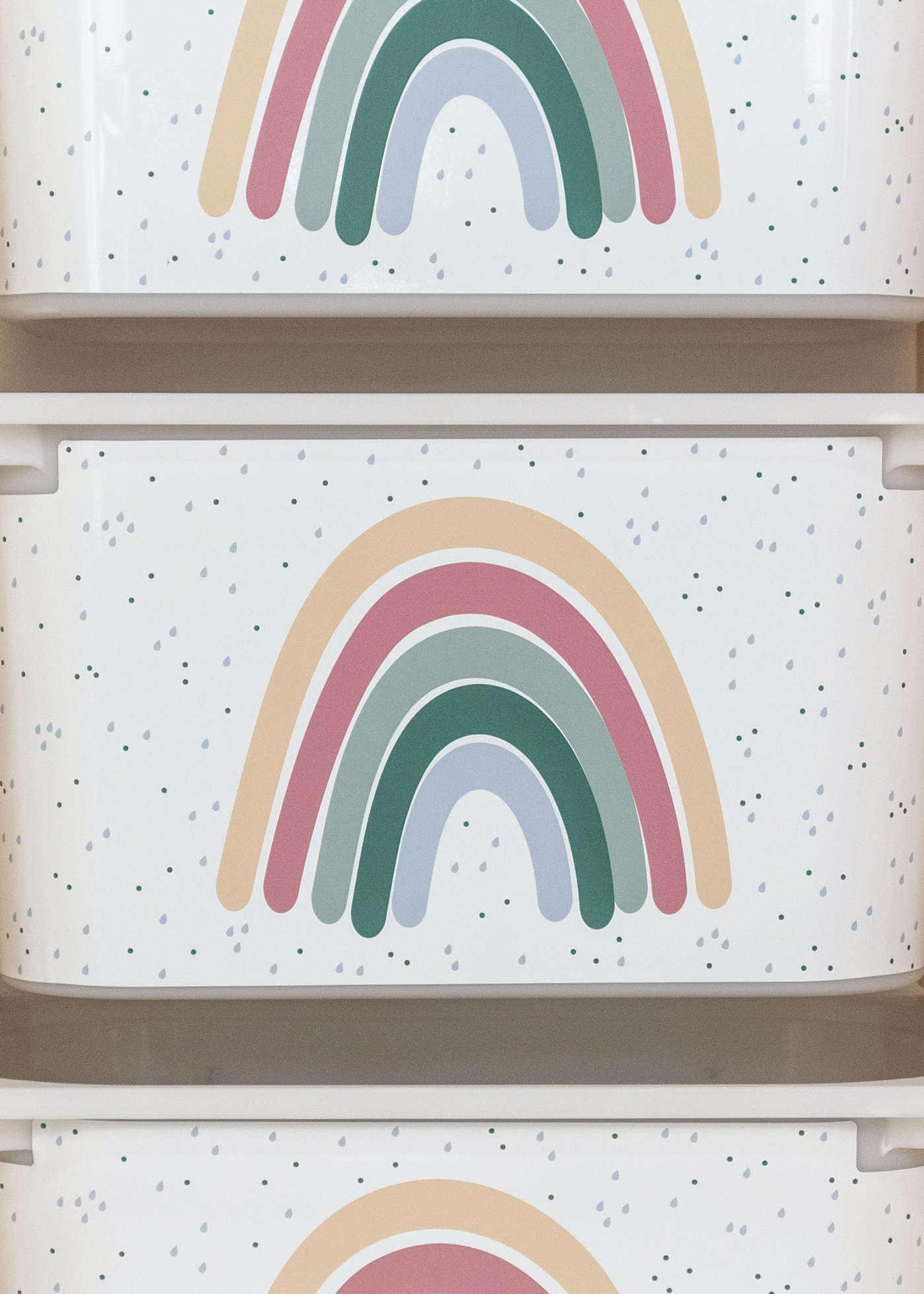 Beige Box mit Regenbogen im IKEA Regal Aufbewahrungsbox im IKEA TROFAST Regalsystem, verziert mit einem großen bunten Regenbogen.