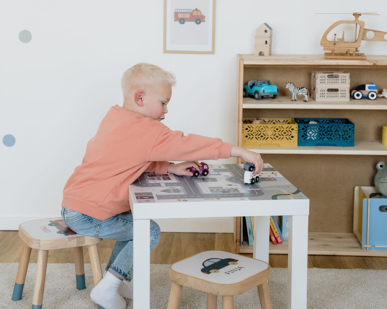 Junge am Spielen mit Autos am Kindertisch Junge am Spielen mit Autos am Kindertisch