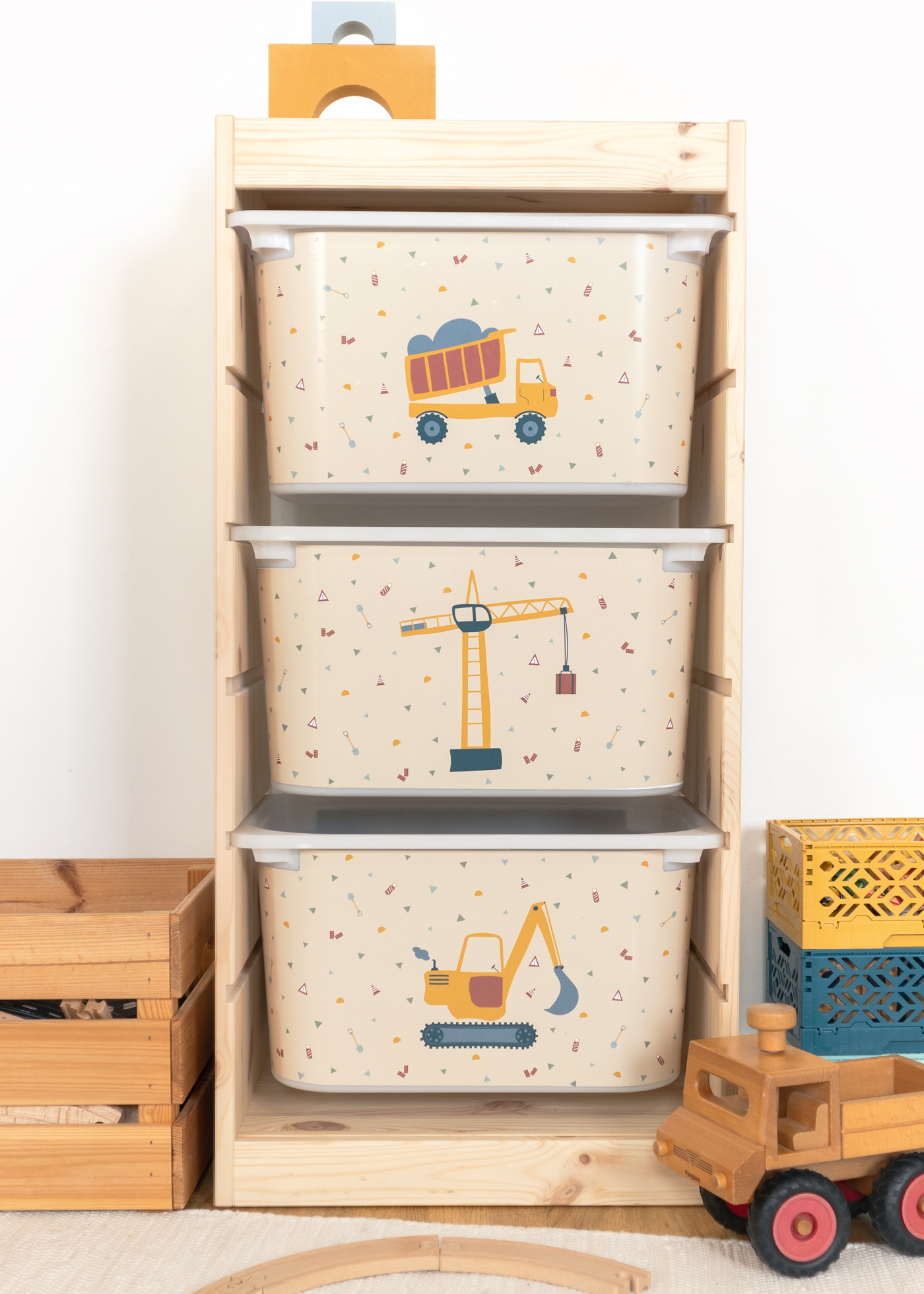 Beige Kran-Motiv Box im Kinderzimmerregal IKEA TROFAST Regal mit kleiner Box, die ein Kran-Motiv zeigt.