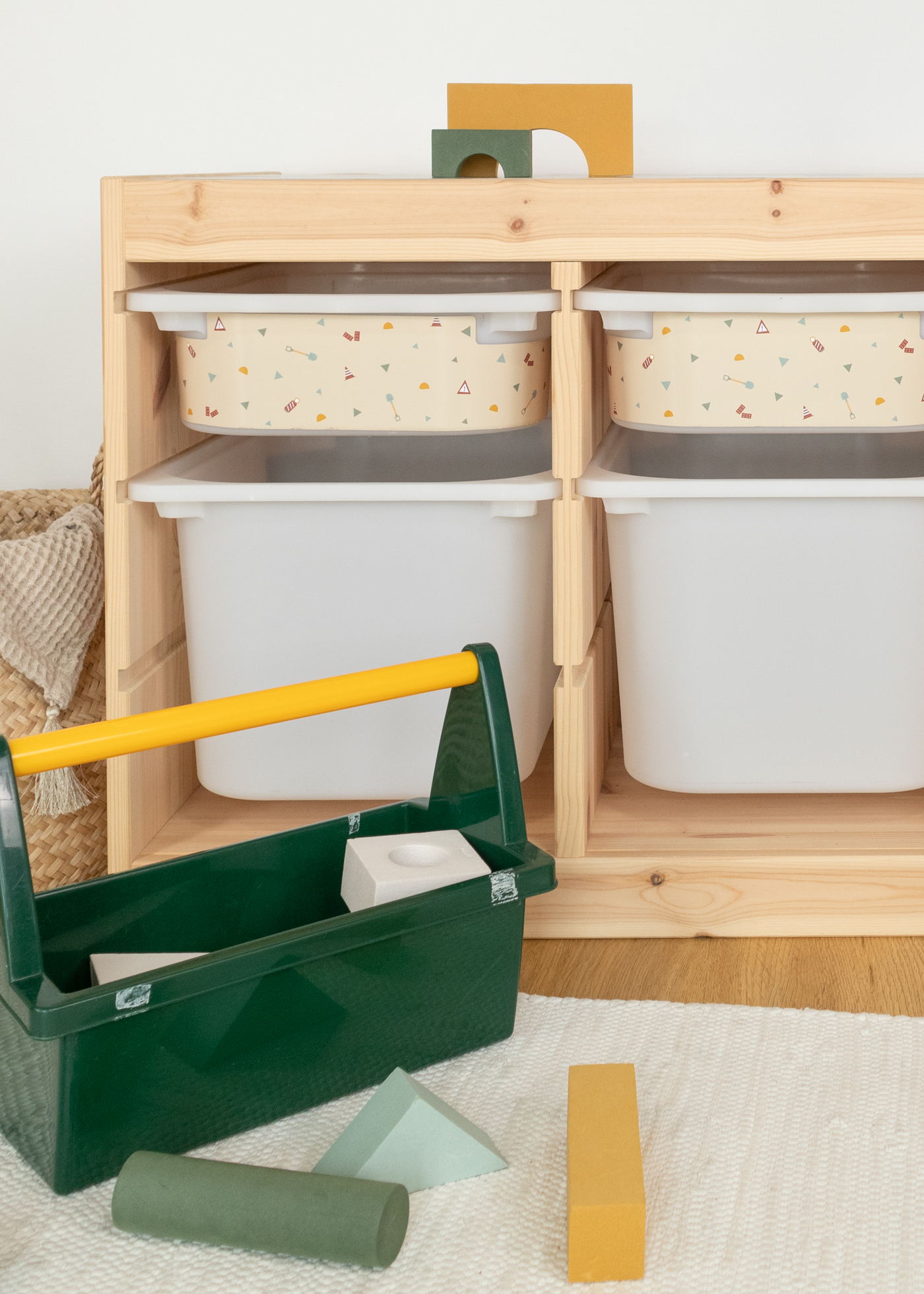 IKEA TROFAST Regal für Kinder mit Bau-Themen-Aufbewahrung Praktische Aufbewahrung im IKEA TROFAST Regal mit einer beige Box, bedruckt mit bunten Bagger-, Kran- und Kipplader-Motiven.