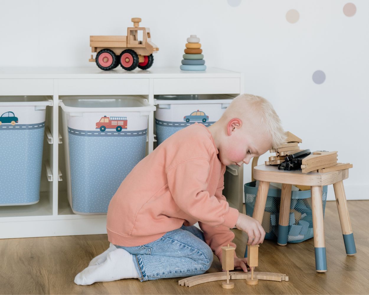 A boy plays with building blocks on the floor of his nursery