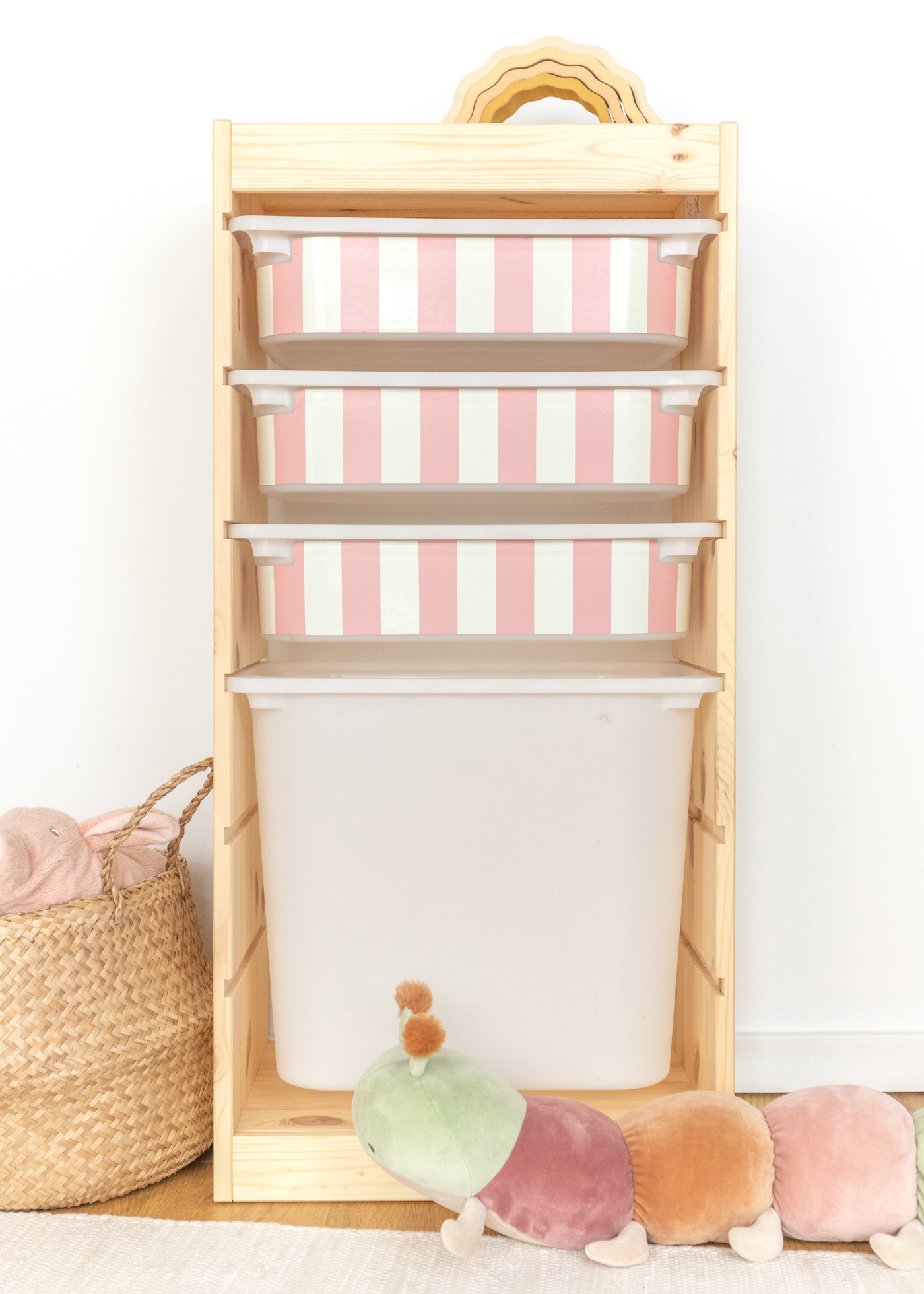 Spielzeugaufbewahrung mit rosa Streifenmuster im IKEA Regal IKEA TROFAST Regal mit Box, dekoriert mit einem eleganten rosa Streifenmotiv.
